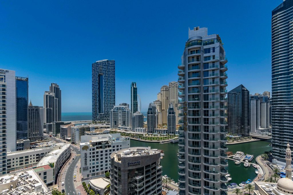 Towers along the Dubai Marina waterway under a clear sky
